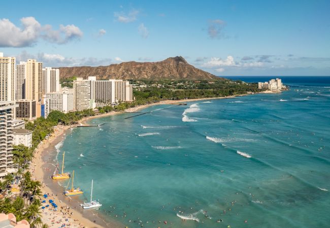 A scenic view of Waikiki Beach in Honolulu, Hawaii, featuring beachfront hotels, turquoise waters, and the iconic Diamond Head crater.